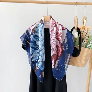 Detail of 90x90cm floral chiffon scarf draped elegantly over a black dress in a lifestyle setting