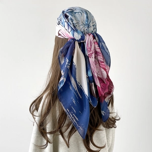 Floral print satin silk square scarf in deep blue and magenta worn as a headscarf