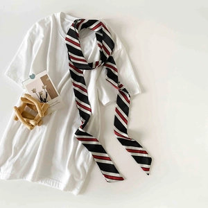 Detailed close-up of a striped narrow twilly scarf tied on a white t-shirt collar