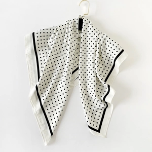 Close-up of black polka dot pattern and stripe edge on premium silk-like square scarf
