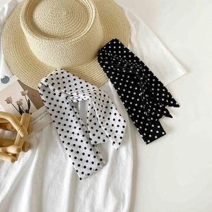Polka dot skinny silk scarf set in black and white on casual white t-shirt background