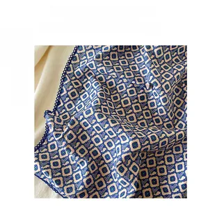 Close-up of cotton leopard print scarf with dark blue crocheted lace edges and floral texture