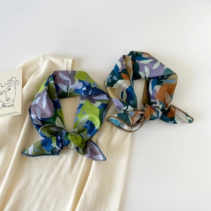 Close-up of lightweight cotton square scarves with floral prints and crochet lace edges