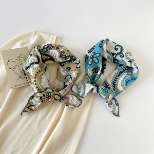 Detailed view of paisley silk scarves tied on a knit vest with elegant pattern details