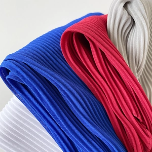 Detailed macro view of plissé chiffon fabric showing fine pleated texture in multiple colors