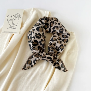Detail of leopard print cotton scarf featuring elegant brown lace trim on soft fabric