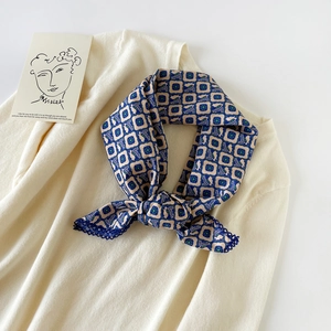 Detailed macro of leopard print cotton scarf with blue lace edge on beige knitwear
