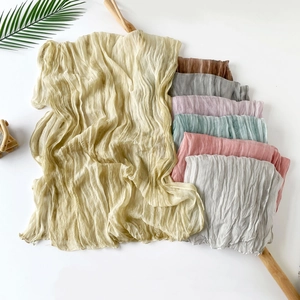 Close-up of pleated lightweight chiffon scarves in various solid colors with texture