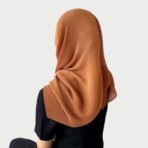 Detail of caramel pleated chiffon hijab showing the lightweight fabric texture and pleats