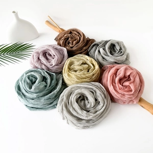 Artistic layout of lightweight pleated jersey scarves in seven elegant solid colors
