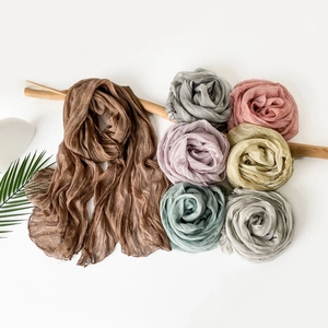 Detail view of lightweight pleated jersey scarves in various soft pastel color options