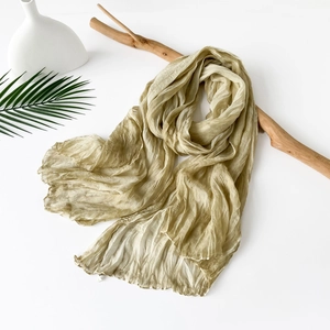Close-up of olive green pleated scarf with elegant crinkle texture and soft silk fabric