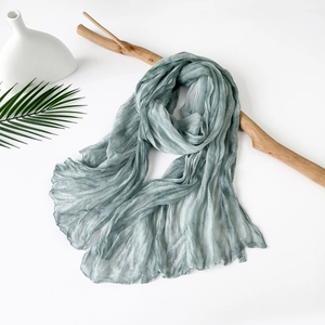 Detail of light blue pleated scarf showing fine texture and 100% polyester wash label