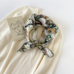 Close-up of paisley pattern cotton scarf with dark green crochet lace trim details