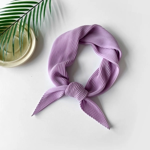 Detailed close-up of lavender pleated chiffon scarf with refined texture and knotted style