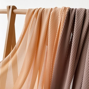Detailed view of champagne and coffee pleated scarves with plisse fabric texture