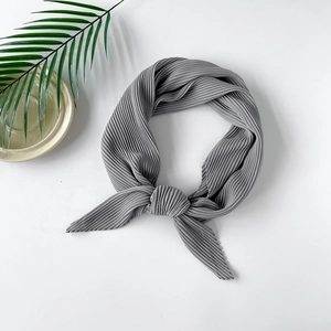 Detail of grey pleated chiffon headscarf showing vertical texture and soft fabric folds