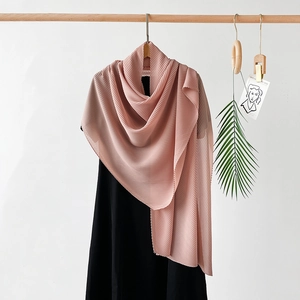 Detail showing dusty rose pleated scarf texture and delicate wavy edge on black dress