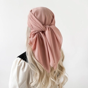 Detail view of pink chiffon headscarf tied elegantly on golden wavy hair
