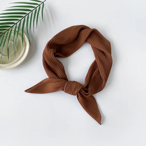 Detail of caramel pleated chiffon scarf with fine accordion pleats and texture