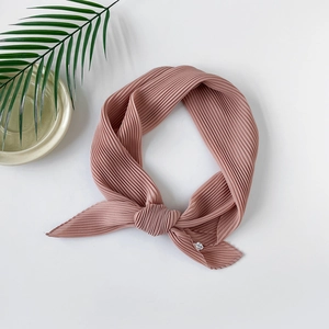 Detail of dusty rose pleated chiffon turban showing the fine fabric texture and knotted design