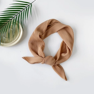 Macro detail of khaki pleated chiffon hijab showing elegant texture and fabric folds