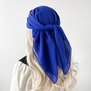 Detail view of royal blue chiffon scarf tied as a hijab with soft textured fabric