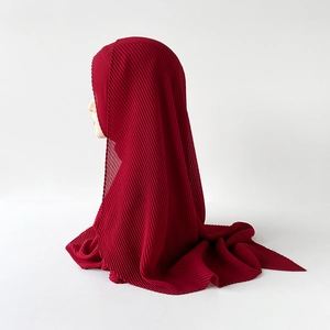 Detail of dark red pleated chiffon hijab scarf showing vertical plissé fabric texture
