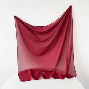 Detail of burgundy chiffon scarf showing lightweight translucent fabric and elegant drape
