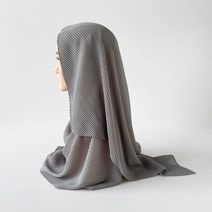 Detailed view of grey pleated chiffon hijab fabric texture on a mannequin