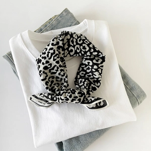 Silk texture square scarf featuring black and white leopard print flat lay on casual outfit