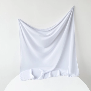 Detailed close-up of white pearl chiffon square hijab fabric with wash label detail