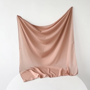 Detailed close-up of light pink chiffon square scarf featuring premium fabric texture and drape