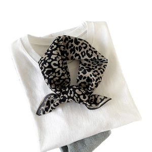 Fashionable leopard print silk scarf styled as a neckerchief on a white t-shirt