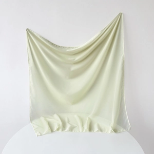 Detail of light green satin scarf showing silky texture and delicate rolled edges