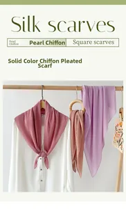 Detail of pleated pearl chiffon scarves in soft morandi tones hanging on wooden racks