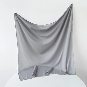 Detail of grey chiffon hijab fabric showing delicate hemmed edges and lightweight texture