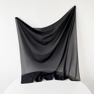 Detail shot of sheer black chiffon scarf showing lightweight texture and elegant drape