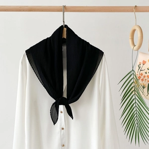 Detailed view of black pleated chiffon scarf draped elegantly over a white shirt