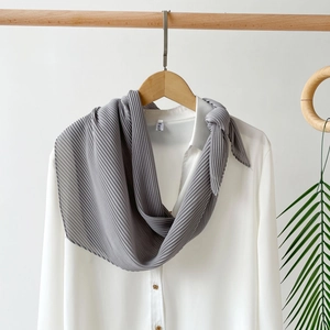 Close-up of middle grey pleated chiffon scarf showing fine texture on a white shirt