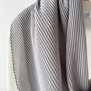 Detailed macro view of light gray pleated chiffon scarf with fine vertical texture
