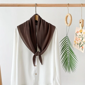 Detailed view of dark coffee pleated chiffon scarf displayed on a wooden hanger with white shirt