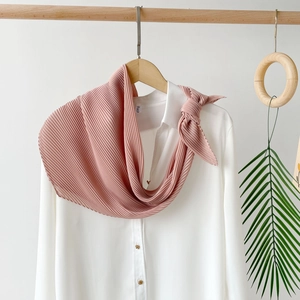 Detail of pink pleated chiffon scarf texture hanging with elegant white shirt