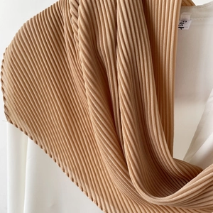 Close-up of elegant caramel pleated chiffon hijab scarf with detailed accordion folds