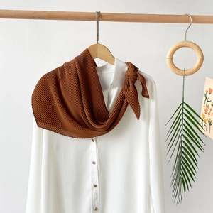 Detail of dark brown pleated chiffon headscarf with fine accordion texture and bow tied style
