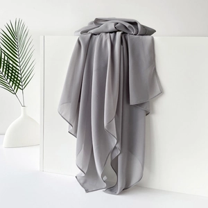 Detail eines grauen einfarbigen Satin-Hijabs mit glatter Chiffon-Textur und Saumkante