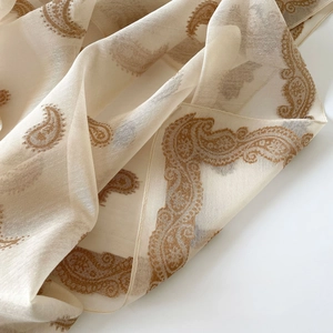 Close-up of lightweight paisley floral print silk scarf in off-white and brown tones