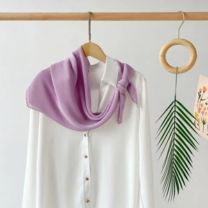 Detail of light purple pleated chiffon headscarf with wavy edges on white shirt