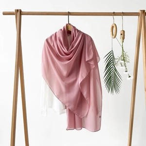 Detail eines zartrosa Schal-Hijabs aus Chiffon mit elegantem Fall auf einem Bügel