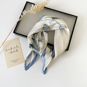 Detail of 70cm pleated silk scarf featuring blue floral print on white satin fabric